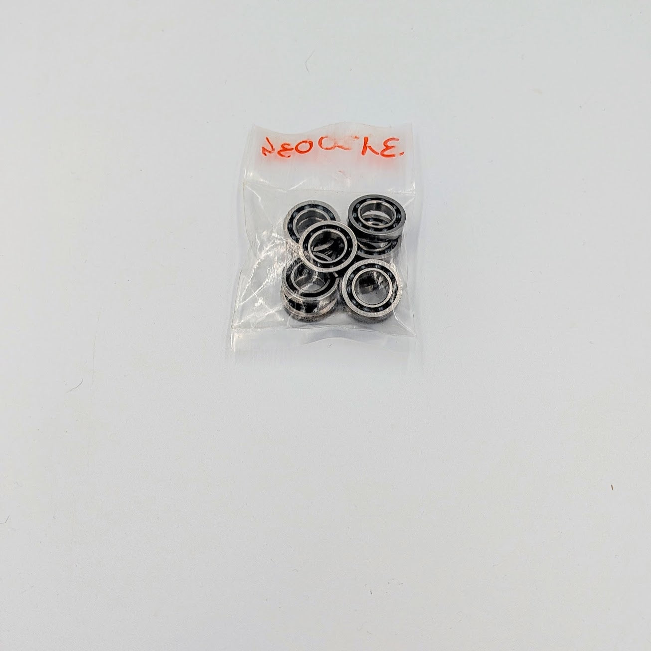 Pack of metal bearings in a clear plastic bag on a white background
